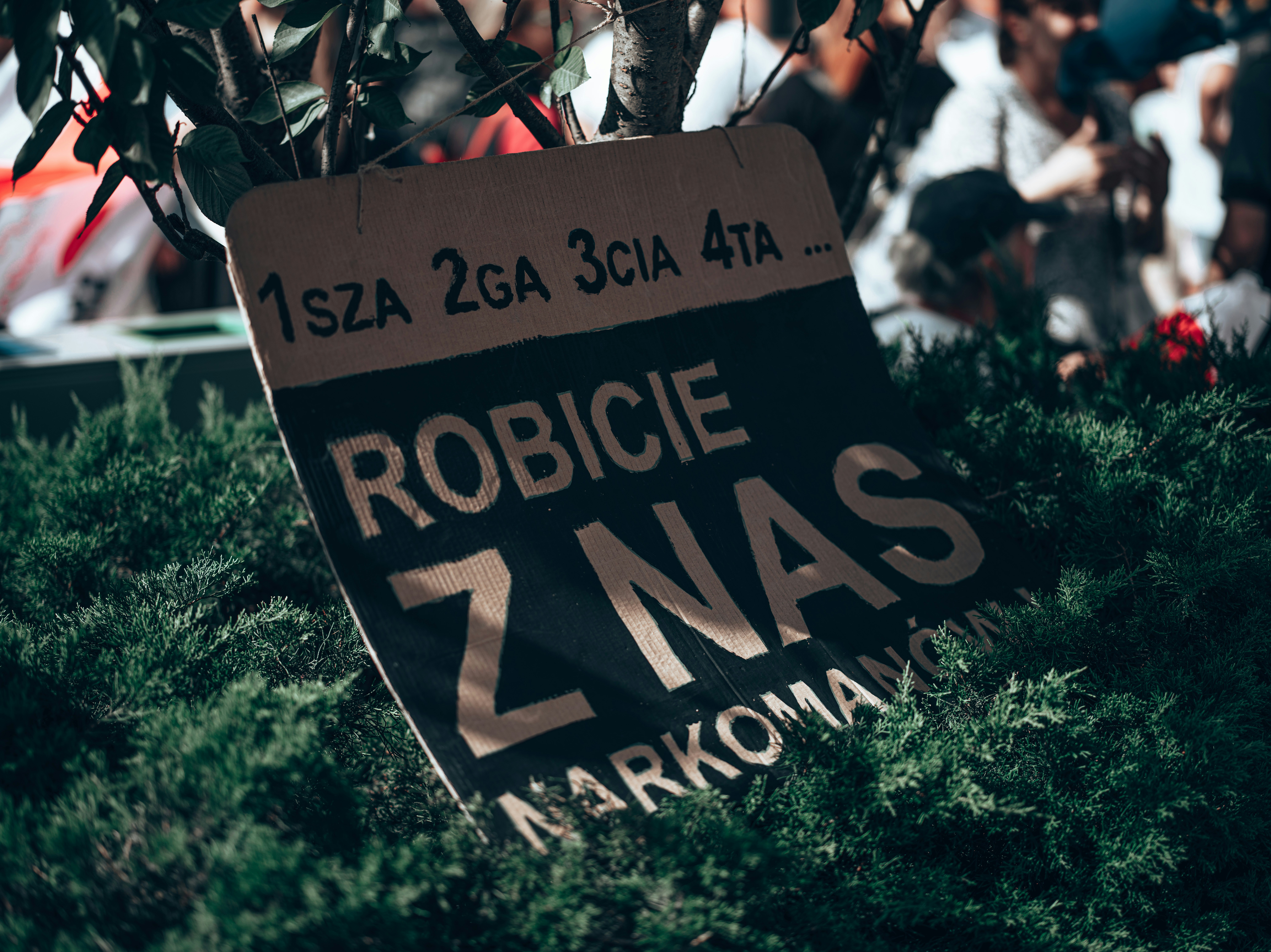 a sign in front of a crowd
